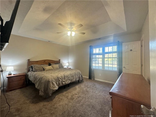 carpeted bedroom featuring ceiling fan, a textured ceiling, and a tray ceiling