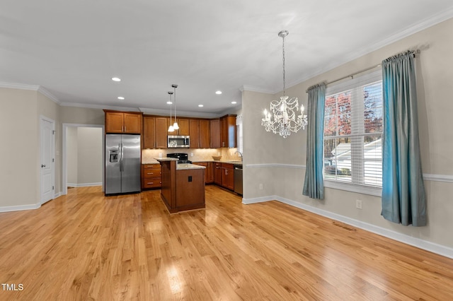 kitchen featuring decorative light fixtures, a kitchen island, appliances with stainless steel finishes, and light hardwood / wood-style flooring