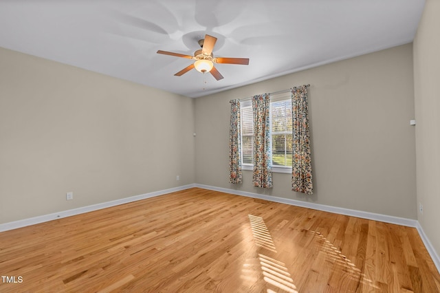 empty room with ceiling fan and light hardwood / wood-style flooring