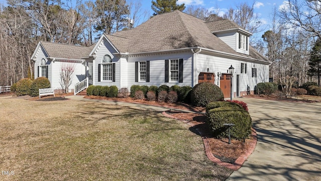 view of front of house featuring a garage and a front lawn