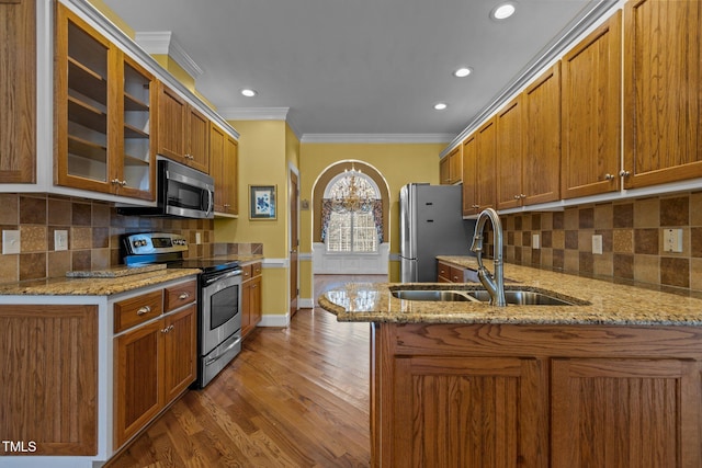 kitchen featuring appliances with stainless steel finishes, sink, light stone counters, and kitchen peninsula