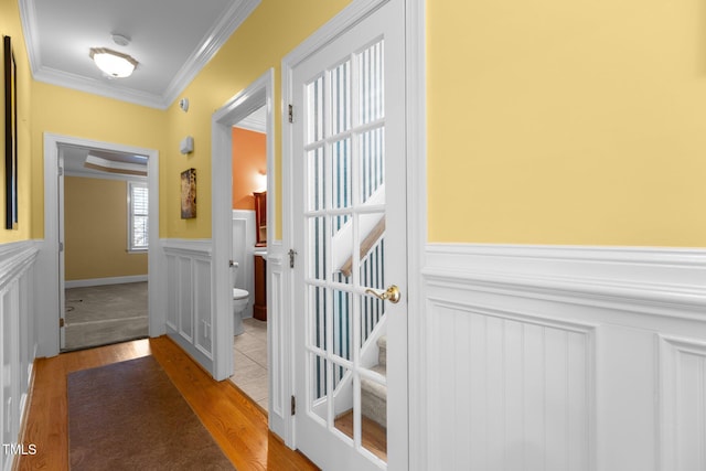 doorway featuring ornamental molding and light hardwood / wood-style floors