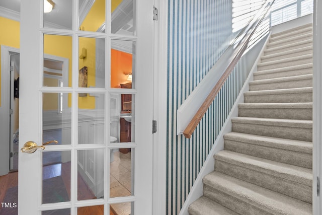 stairway with tile patterned flooring, ornamental molding, and french doors