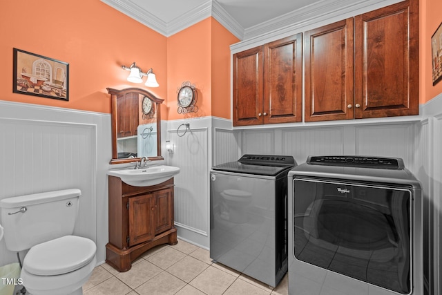 laundry area featuring washing machine and dryer, sink, light tile patterned flooring, and crown molding