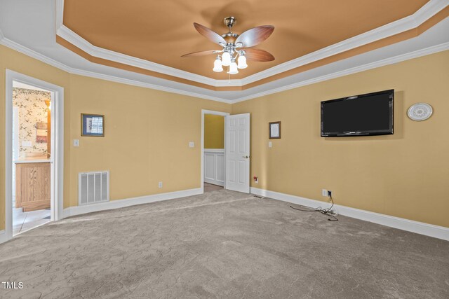 empty room with a raised ceiling and light carpet