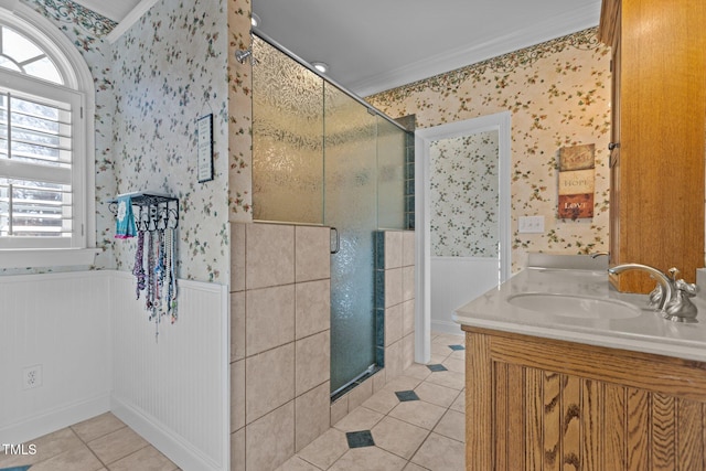 bathroom featuring a shower with door, vanity, ornamental molding, and tile patterned floors