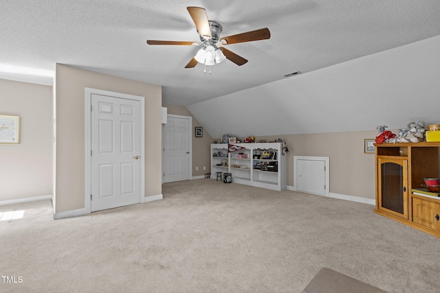 interior space featuring lofted ceiling, light carpet, and a textured ceiling