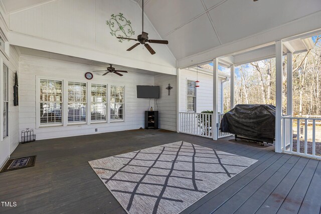 unfurnished sunroom featuring lofted ceiling, a wealth of natural light, and a wood stove