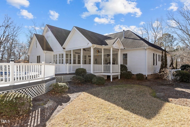 exterior space with a wooden deck, a yard, and ceiling fan