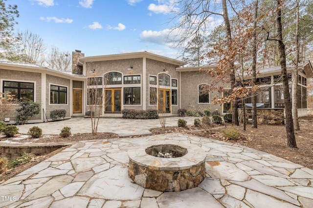 back of property with a patio and a fire pit