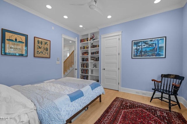 bedroom featuring hardwood / wood-style floors, crown molding, and ceiling fan