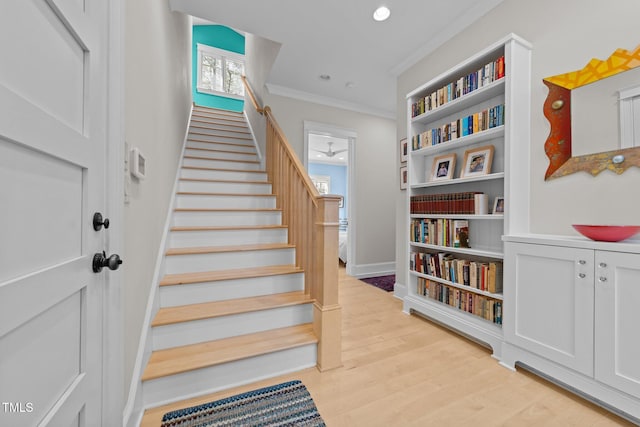 staircase featuring crown molding and wood-type flooring