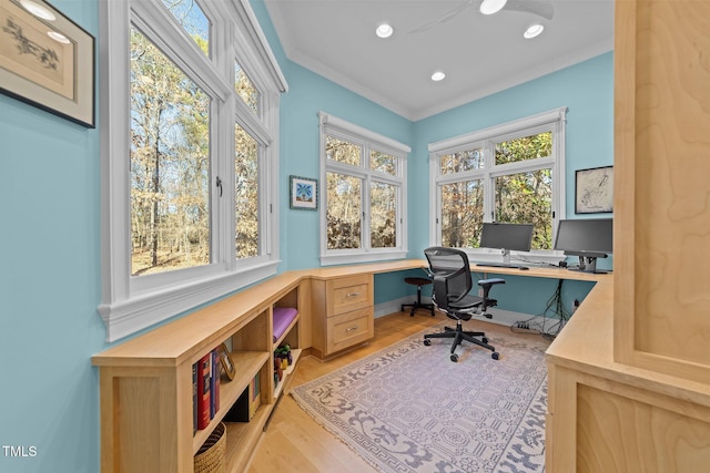 office area with ornamental molding, built in desk, and light wood-type flooring