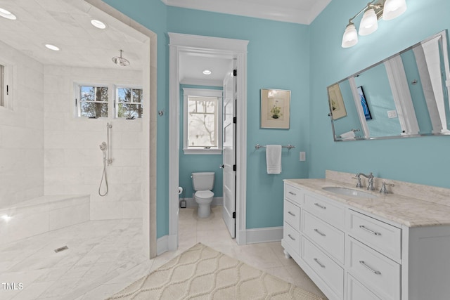 bathroom featuring tile patterned floors, toilet, crown molding, a tile shower, and vanity