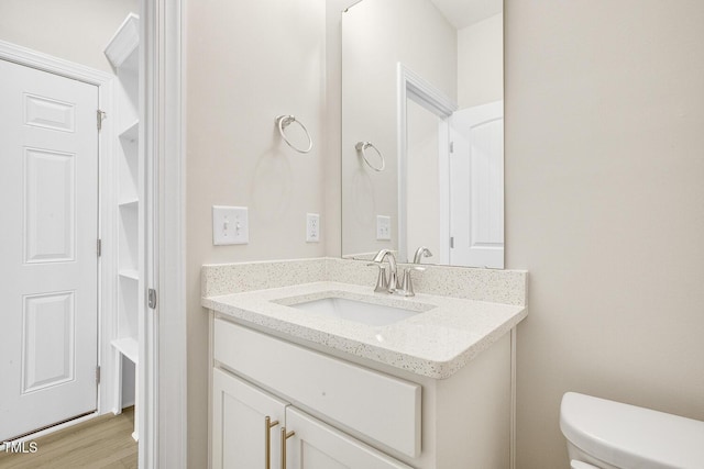 bathroom featuring wood finished floors, vanity, and toilet