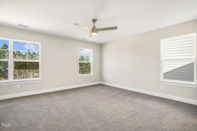 spare room with carpet floors, visible vents, baseboards, and a ceiling fan