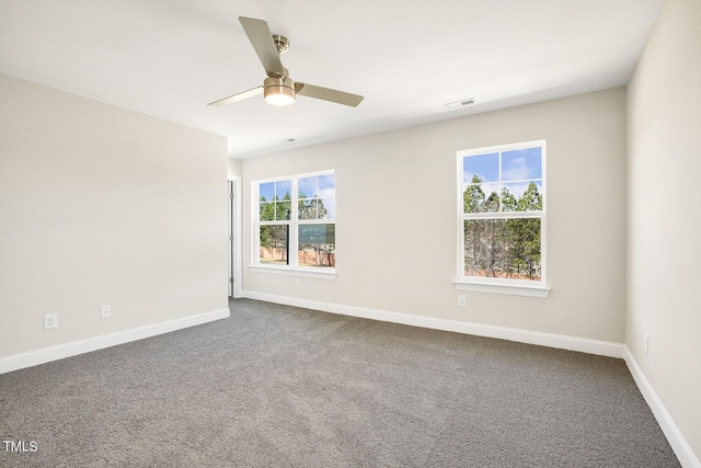 spare room featuring visible vents, baseboards, dark colored carpet, and a ceiling fan