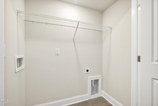 laundry room featuring dark wood-type flooring, electric dryer hookup, and baseboards