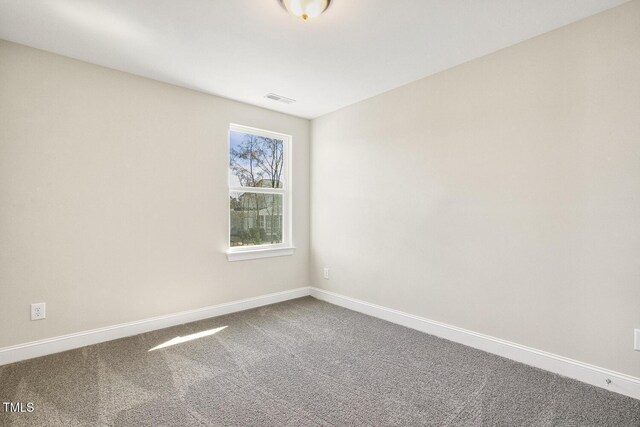 carpeted empty room featuring baseboards and visible vents