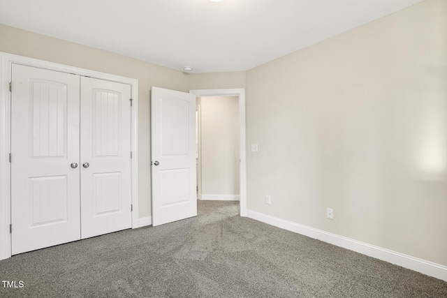 unfurnished bedroom featuring carpet, a closet, and baseboards