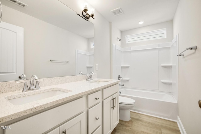 full bathroom featuring toilet, visible vents, a sink, and wood finished floors