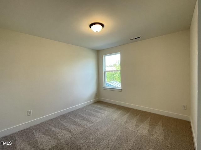 unfurnished room with baseboards, carpet flooring, and visible vents