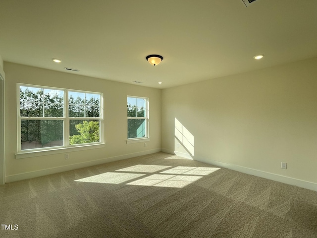 empty room featuring baseboards, visible vents, recessed lighting, and light colored carpet