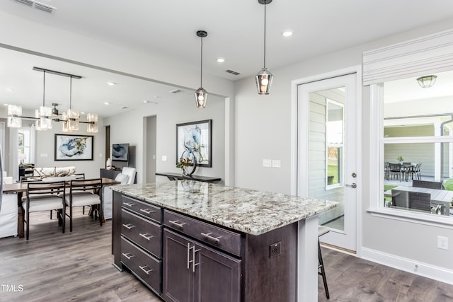 kitchen featuring a breakfast bar, dark hardwood / wood-style flooring, and a healthy amount of sunlight