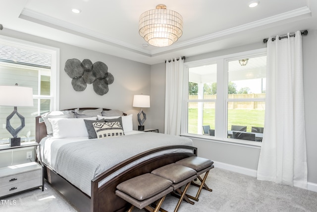 bedroom with light carpet, a tray ceiling, and ornamental molding