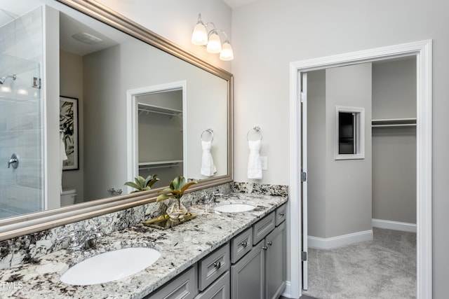 bathroom featuring vanity, a shower with shower door, and toilet