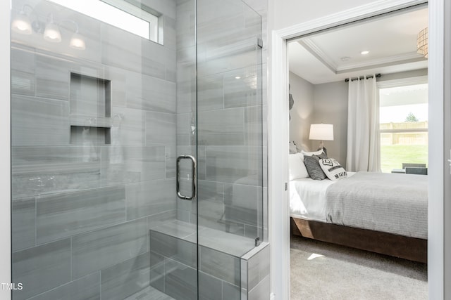 bathroom featuring a raised ceiling, an enclosed shower, and ornamental molding