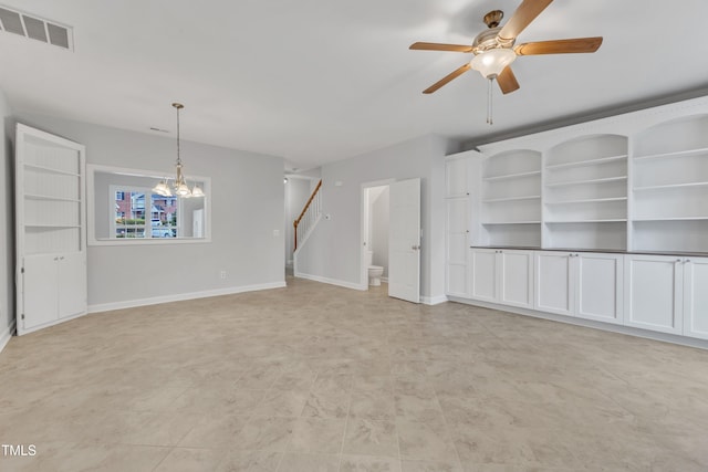 unfurnished living room with ceiling fan with notable chandelier