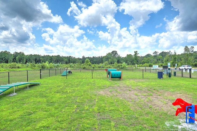 view of home's community with fence and a yard