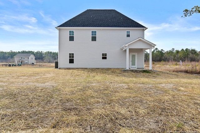 back of property with a shingled roof