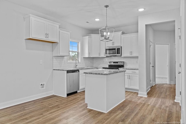 kitchen with white cabinetry, appliances with stainless steel finishes, light wood-style flooring, and a sink