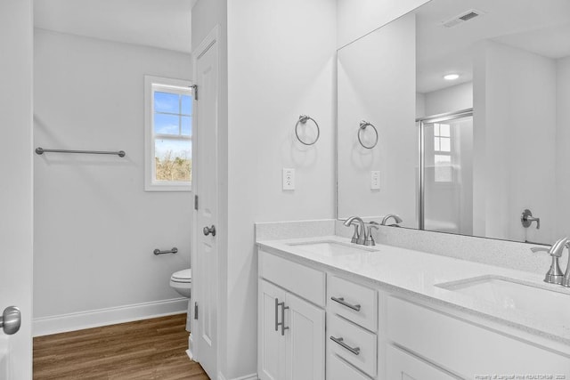 bathroom with a shower with door, a sink, visible vents, and baseboards