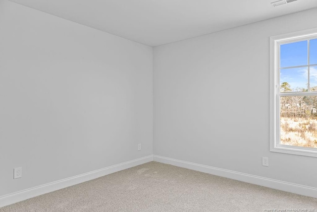 empty room with light carpet, visible vents, and baseboards