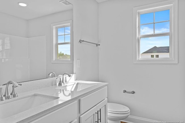 full bath featuring visible vents, double vanity, a sink, and toilet