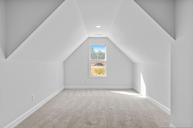 additional living space with lofted ceiling, carpet flooring, visible vents, and baseboards