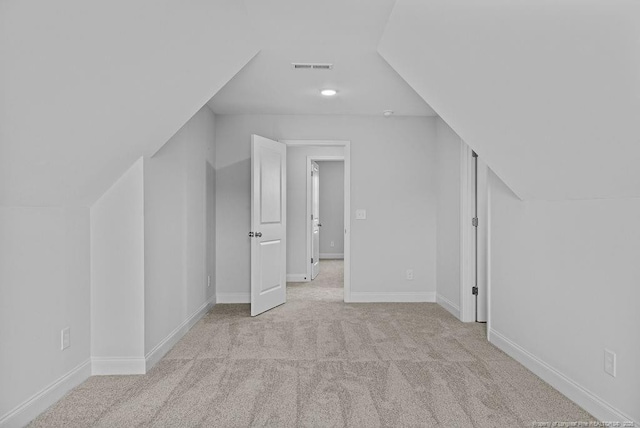 bonus room with baseboards, visible vents, and light colored carpet