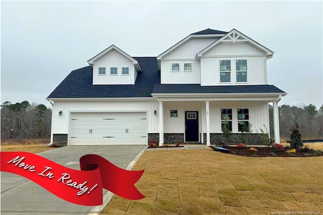 view of front facade with concrete driveway, stone siding, an attached garage, covered porch, and a front yard