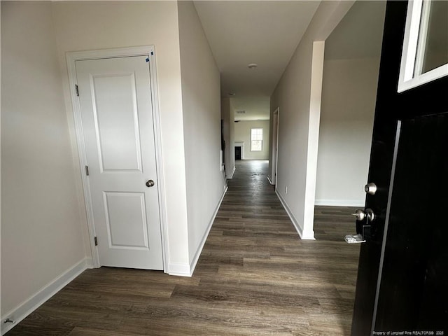 hall with dark wood finished floors and baseboards