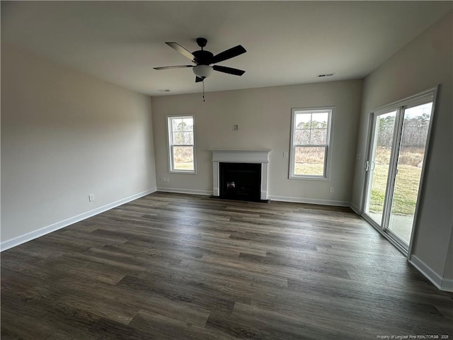 unfurnished living room with ceiling fan, a fireplace with flush hearth, visible vents, baseboards, and dark wood-style floors