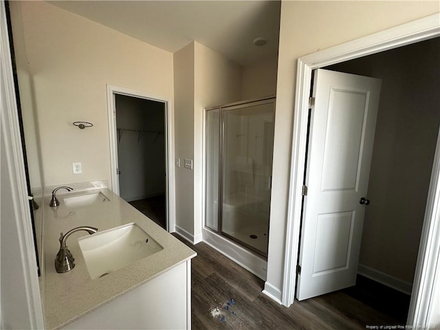 bathroom with a sink, a shower stall, and wood finished floors