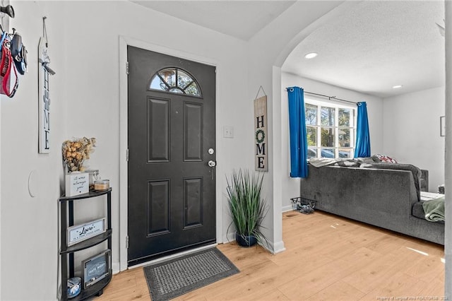 foyer featuring hardwood / wood-style floors, a healthy amount of sunlight, and a textured ceiling