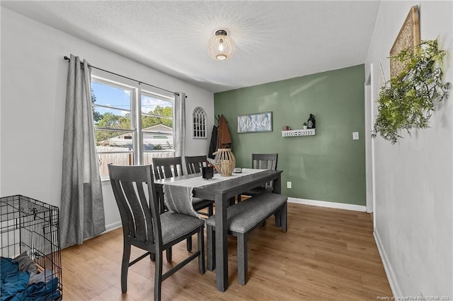 dining area featuring hardwood / wood-style floors and a textured ceiling