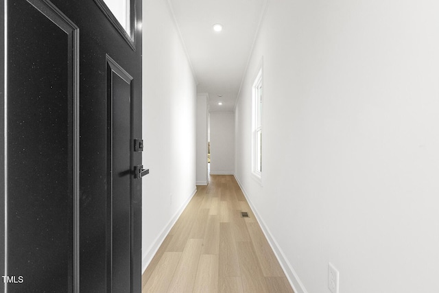 corridor with crown molding and light hardwood / wood-style floors