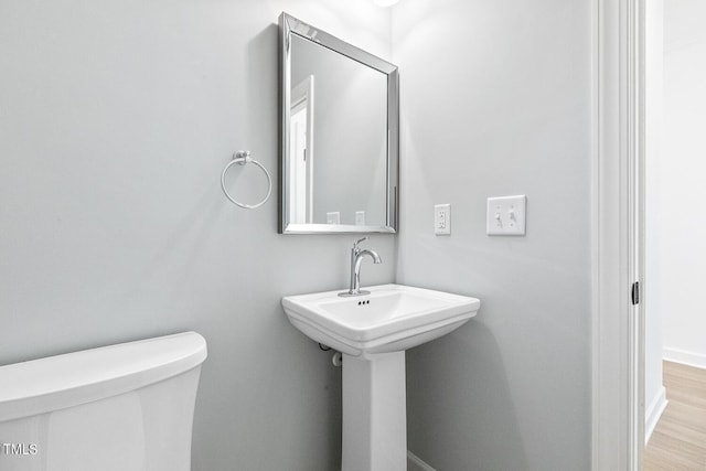 bathroom with hardwood / wood-style floors and toilet