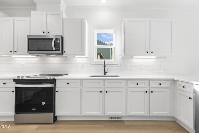 kitchen featuring white cabinets, stainless steel appliances, and light hardwood / wood-style flooring