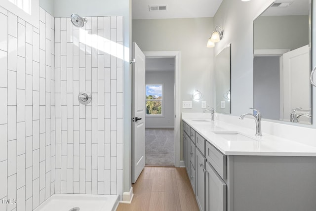 bathroom with a tile shower, vanity, and hardwood / wood-style flooring